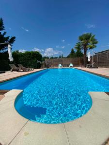 a large swimming pool with blue water at Gîtes de La Condamine in Curbans