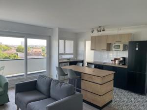 a kitchen and living room with a couch and a table at Chambre dans colocation à Lormont proche Bordeaux in Lormont