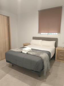 a bedroom with a large bed with white sheets at Edificio Mañez - Bajo in La Línea de la Concepción