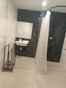 a bathroom with a sink and a shower with a mirror at Edificio Mañez - Bajo in La Línea de la Concepción +3 photos