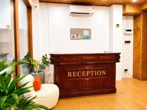 a reception desk in a room with a sign on the wall at Haonorn Hostel in Thong Sala