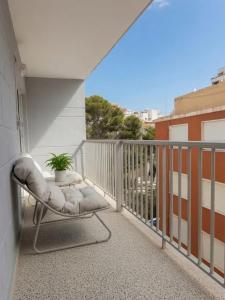 a balcony with a chair and a potted plant at Cullera Beach III in Cullera