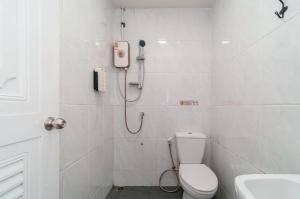 a white bathroom with a shower and a toilet at Nawin Hotel Donmueang in Thung Si Kan