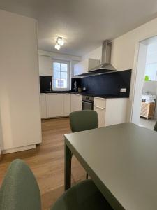 a kitchen with a table and chairs in a room at Soul Apartment in Aalen +7 photos