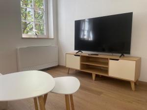a living room with a flat screen tv on a wooden entertainment center at Soul Apartment in Aalen