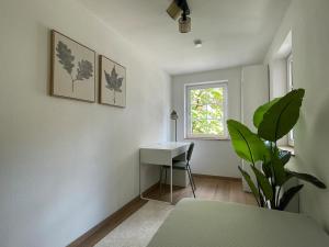 a room with a desk and a plant and a window at Soul Apartment in Aalen