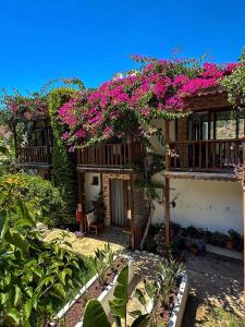 a house with pink flowers on the side of it at Faralya Misafir Evi in Faralya