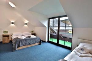 a bedroom with two beds and a large window at Noclegi Onesto in Międzybrodzie Bialskie
