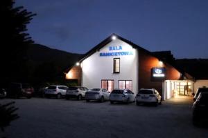 a building with cars parked in a parking lot at night at Noclegi Onesto in Międzybrodzie Bialskie