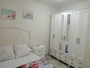 a bedroom with white cabinets and a bed and a dresser at CASA EL CASTAÑÉU in Arriondas