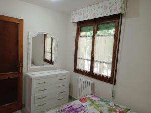 a bedroom with a dresser and a mirror at CASA EL CASTAÑÉU in Arriondas