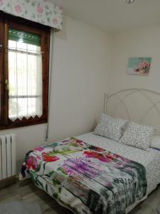 a bedroom with a bed with a quilt on it at CASA EL CASTAÑÉU in Arriondas