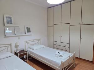 a bedroom with two beds and a large cabinet at Birdsing Cottage in Dassia