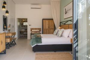 a bedroom with a large bed and a kitchen at Waterfalls Lodge in Victoria Falls