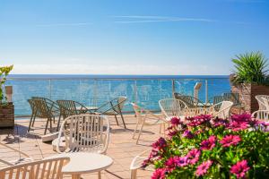 a patio with tables and chairs and the ocean at htop Pineda Palace SPA 4Sup - Bliss - Adults Only Plus 18 in Pineda de Mar