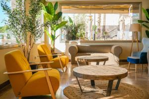 a living room with yellow chairs and tables at htop Pineda Palace SPA 4Sup - Bliss - Adults Only Plus 18 in Pineda de Mar