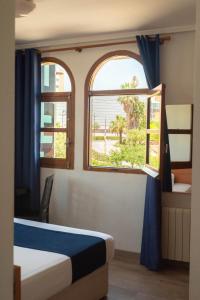 a bedroom with two windows and a bed with blue curtains at SUNDOS Feria Valencia in Valencia +208 photos