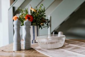 a table with two salt and pepper shakers and a bowl of flowers at Chiemgau Nest II in Siegsdorf