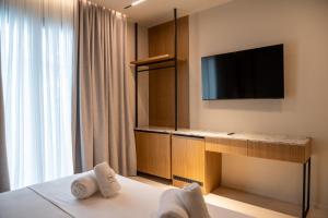 a hotel room with a bed and a flat screen tv at South Inn Marina Hotel in Vlorë