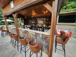 a bar with brown stools and a counter at The Hotel Unforgettable - Hotel Tiliana by Homoky Hotels & Spa in Budapest