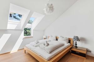 a bedroom with a bed with white sheets and a window at Villa Donau - Sauna & Whirlpool in Vienna