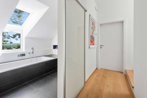 a bathroom with a bath tub and a window at Villa Donau - Sauna & Whirlpool in Vienna +35 photos