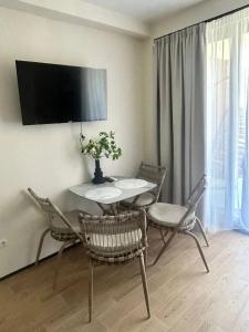 a dining room with a table and chairs and a television at terrace kaprovan in Urekis Sadguri