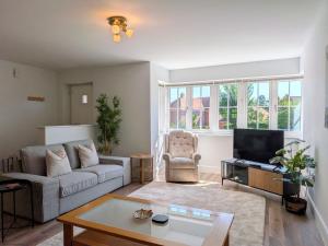 a living room with a couch and a tv at Wyndham Court - Midhurst in Midhurst