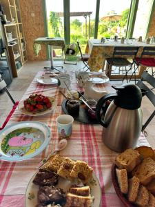 a table topped with plates of food and pastries at Les Jardins Vert Framboise yourte et chambres d'hôtes in Beaufour