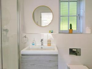 a white bathroom with a sink and a mirror at Wyndham Court - Midhurst in Midhurst +22 photos