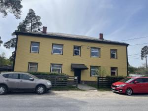 two cars parked in front of a yellow house at Tulika korter in Paralepa