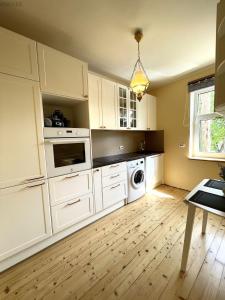 a kitchen with white cabinets and a washer and dryer at Tulika korter in Paralepa