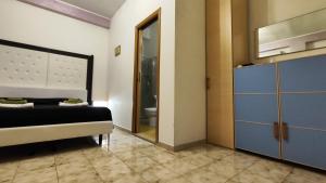 a bedroom with a bed and a bathroom with a mirror at Bed Anthos Porto Cesareo in Porto Cesareo