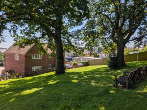 a park with two benches and trees in the grass at Wyndham Court - Midhurst in Midhurst