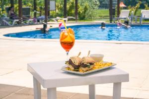 a tray of food and a drink on a table next to a pool at Casa Vlasia in Snagov
