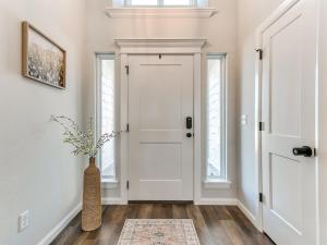 a hallway with a white door and a vase with flowers at New Dream Home in Broken Arrow! in Broken Arrow +41 photos