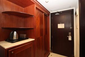a kitchen with wooden cabinets and a door with a microwave at فندق وفاق صدقي in Al ‘Azīzīyah