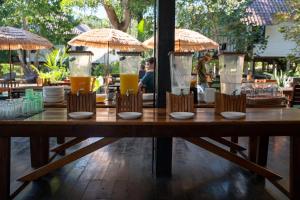 a wooden table with glasses of orange juice at Baan Sawasdee Resort in Ko Lanta