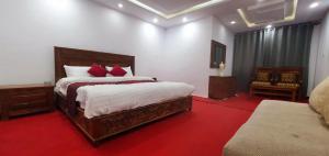 a bedroom with a large bed with red pillows at Villaggio Hotel in Khaplu