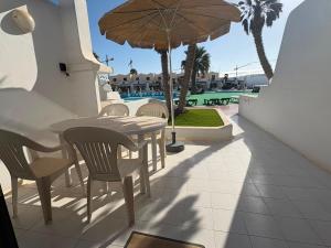 a patio with a table and chairs and an umbrella at Casas Lapa in Costa Teguise