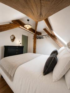 a bedroom with a white bed with two pillows at le petit château in Chambéry