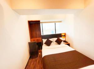 a small room with a bed and a window at HOTEL BLACK BURN in Mumbai