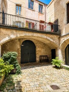 a stone building with a black door and a balcony at le petit château in Chambéry