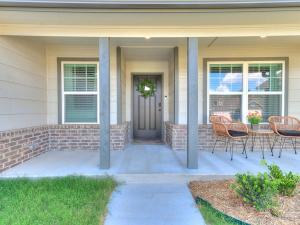 a front porch of a house with chairs and a door at Spacious Retreat with Vaulted Ceilings & Primary Suite! in Broken Arrow
