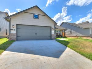 a garage in a house with a driveway at Spacious Retreat with Vaulted Ceilings & Primary Suite! in Broken Arrow