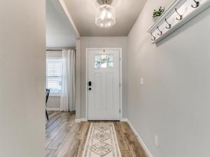 a hallway with a white door and a rug at Spacious Retreat with Vaulted Ceilings & Primary Suite! in Broken Arrow +39 photos
