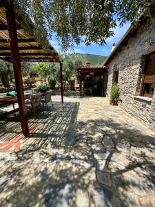 an outdoor patio with a table and a building at Elaion Thea-Nies in Soúrpi +15 photos