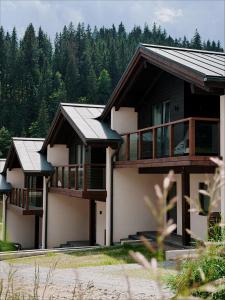 a row of houses with trees in the background at Альпійські шале Душа in Palyanytsya