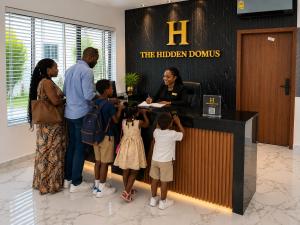 a group of people standing around a reception desk at Executive Cozy Suite at THE HIDDEN DOMUS I Wenchi Suite in Accra