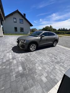 a gray car parked in a parking lot at LOG apartament in Dobrzewino